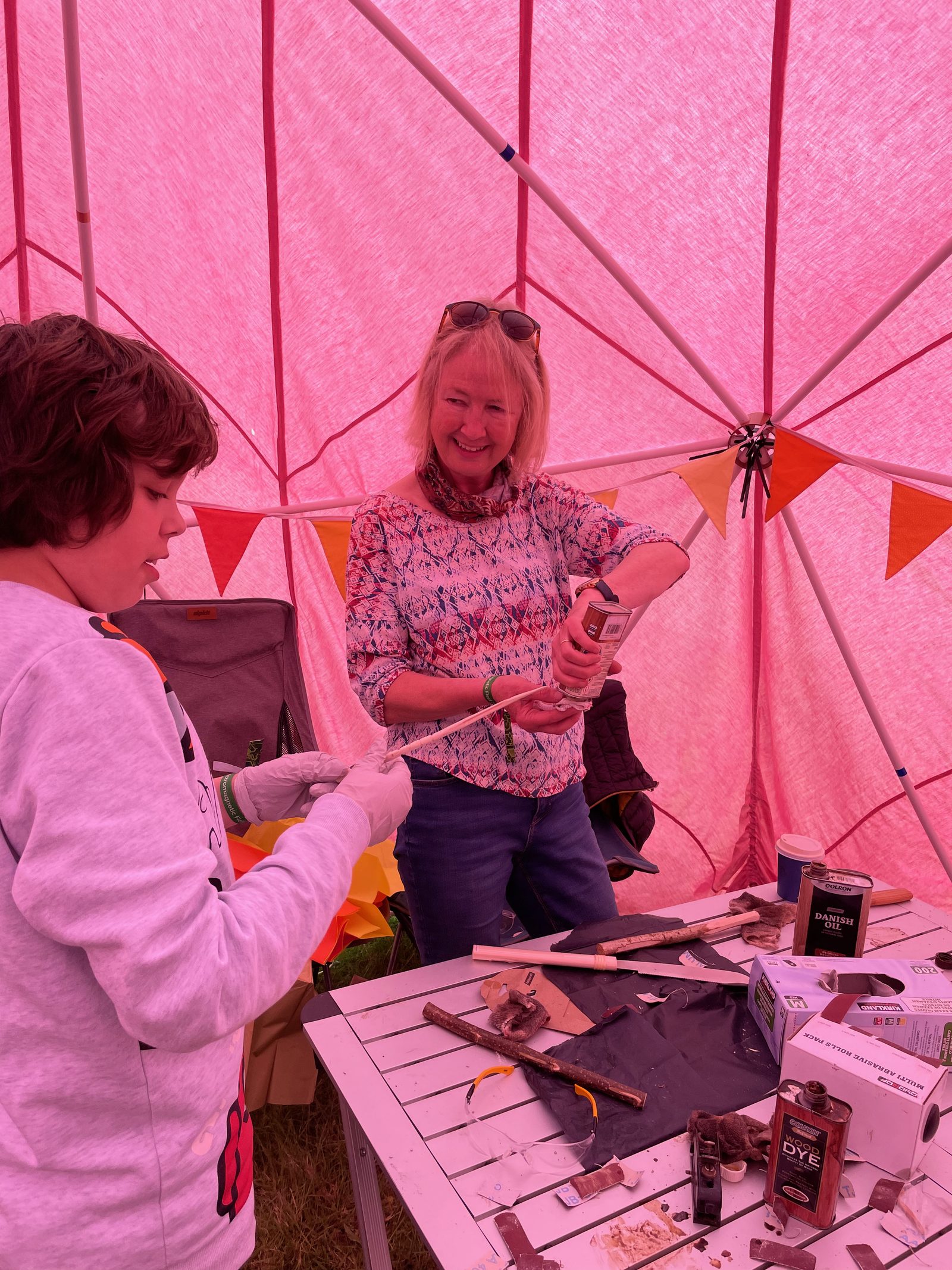 Two people working with materials inside the pink dome